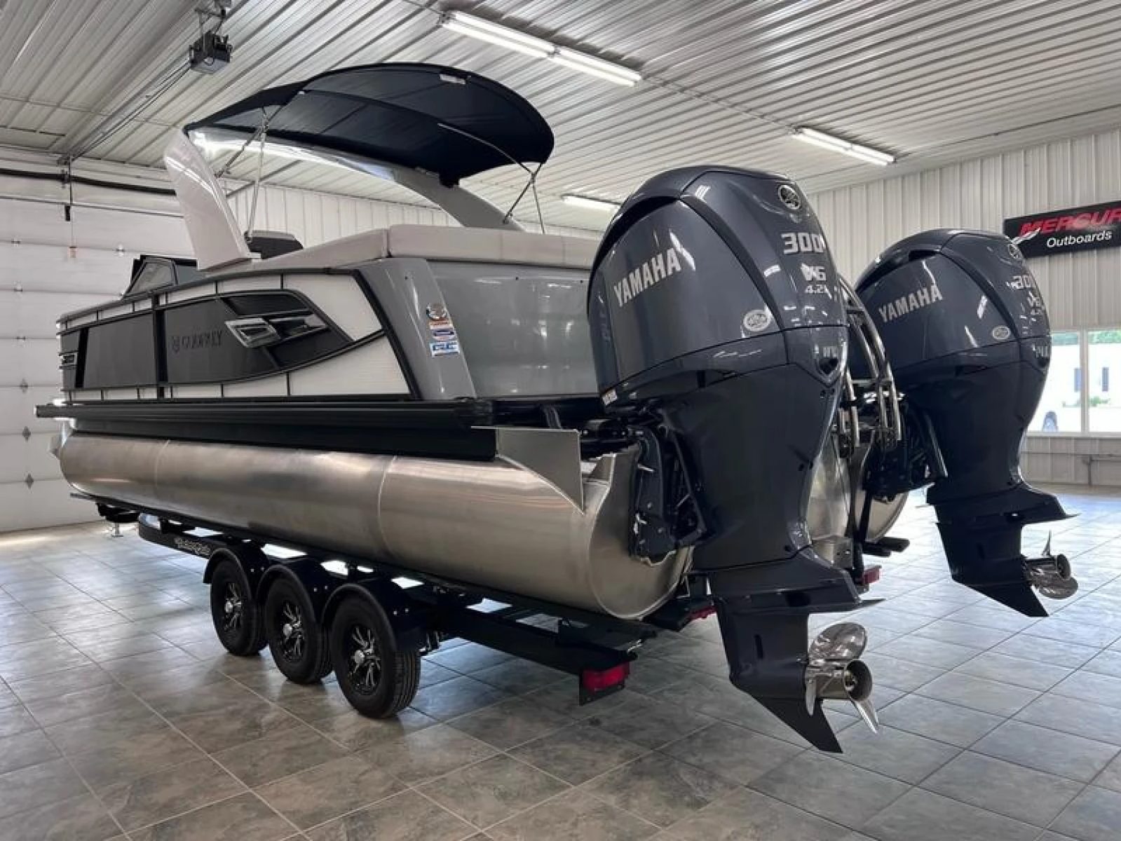 An Aqua Patio tritoon with twin Yamaha 300 outboards in the Lime Lake showroom
